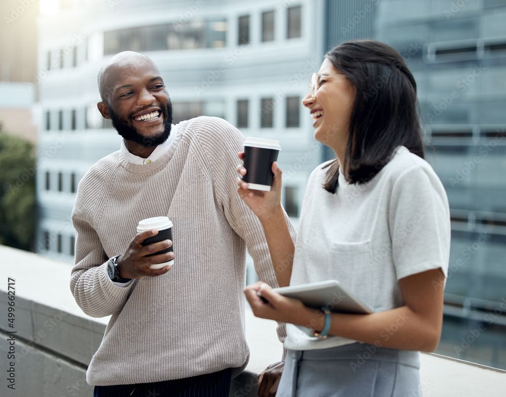 Young couple on a rooftop in a city laughing and drinking hot beverages together