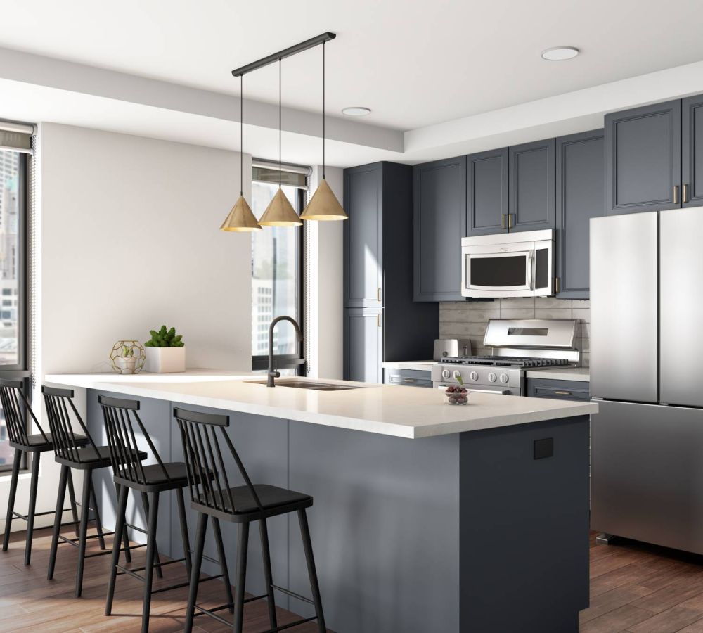 O2 Luxury Towers apartments kitchen with large countertop seating area, gray counters, and modern stainless steel appliances.