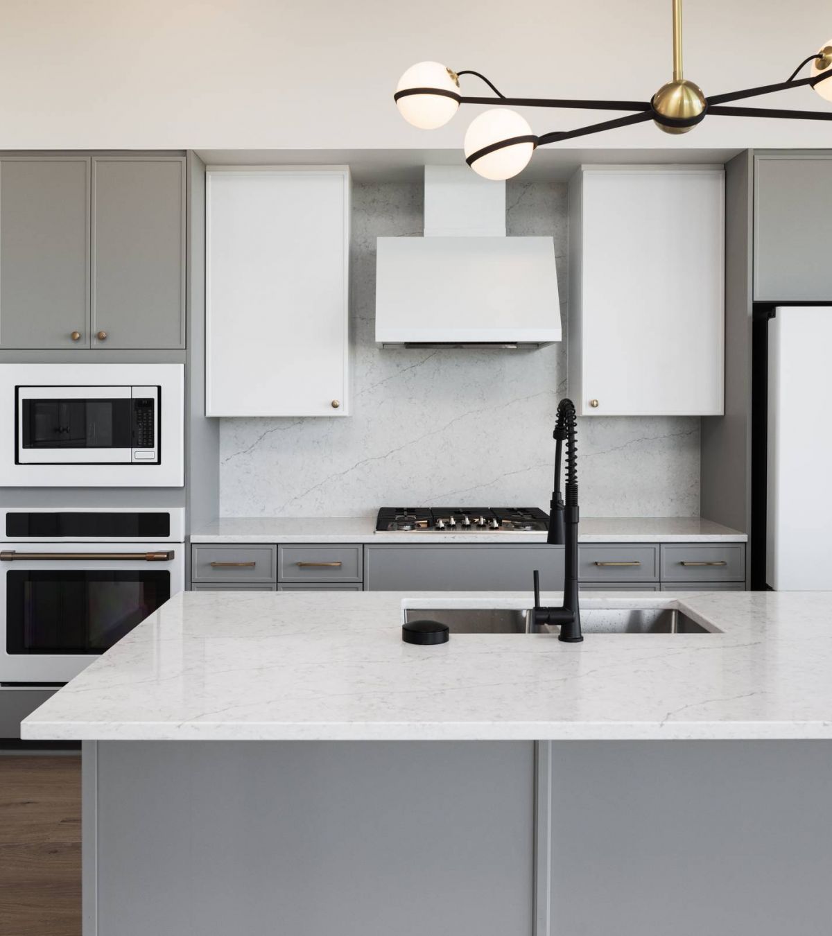 O2 Luxury Tower apartments kitchen with large countertop seating area, gray counters, and modern stainless steel appliances.