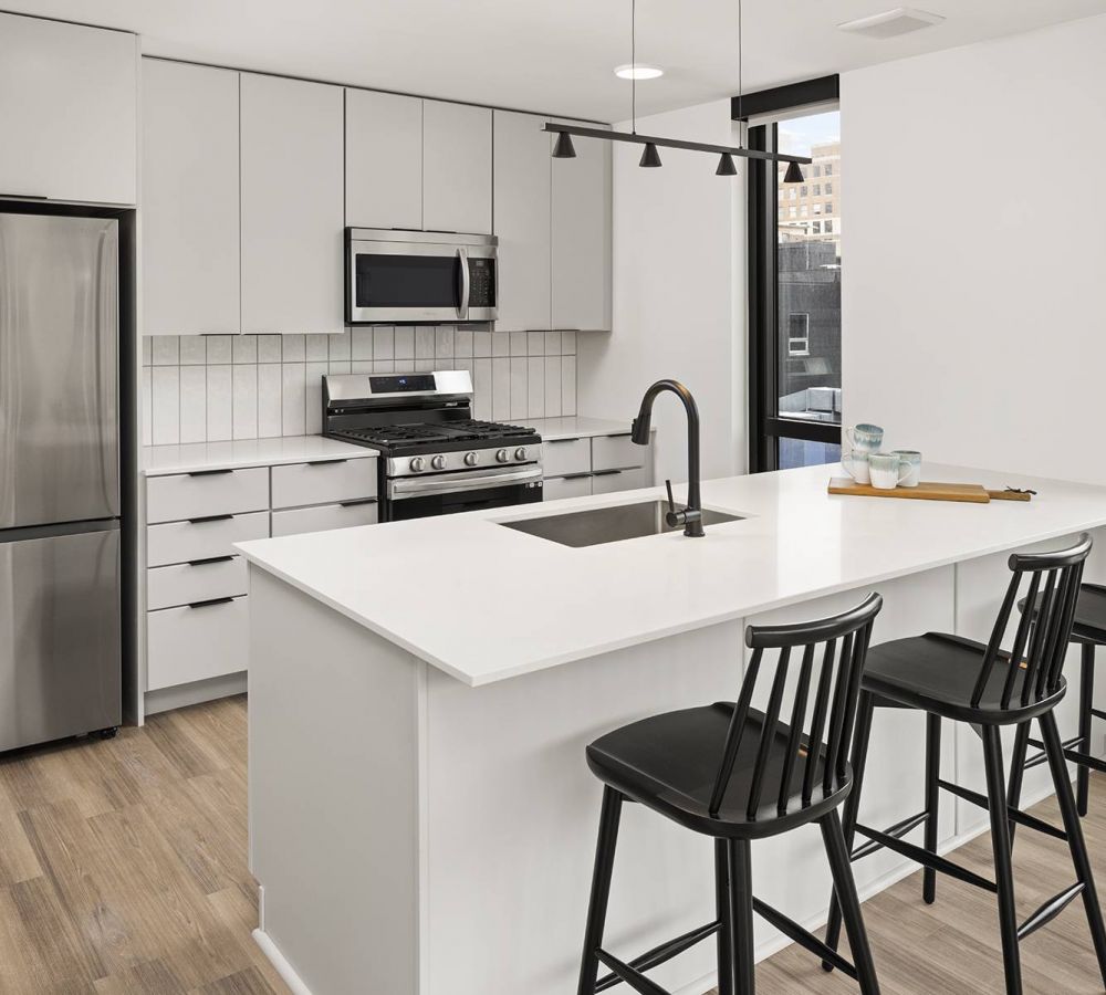 O2 Luxury Towers apartments kitchen with large countertop seating area, ample cabinet space, and modern stainless steel appliances.